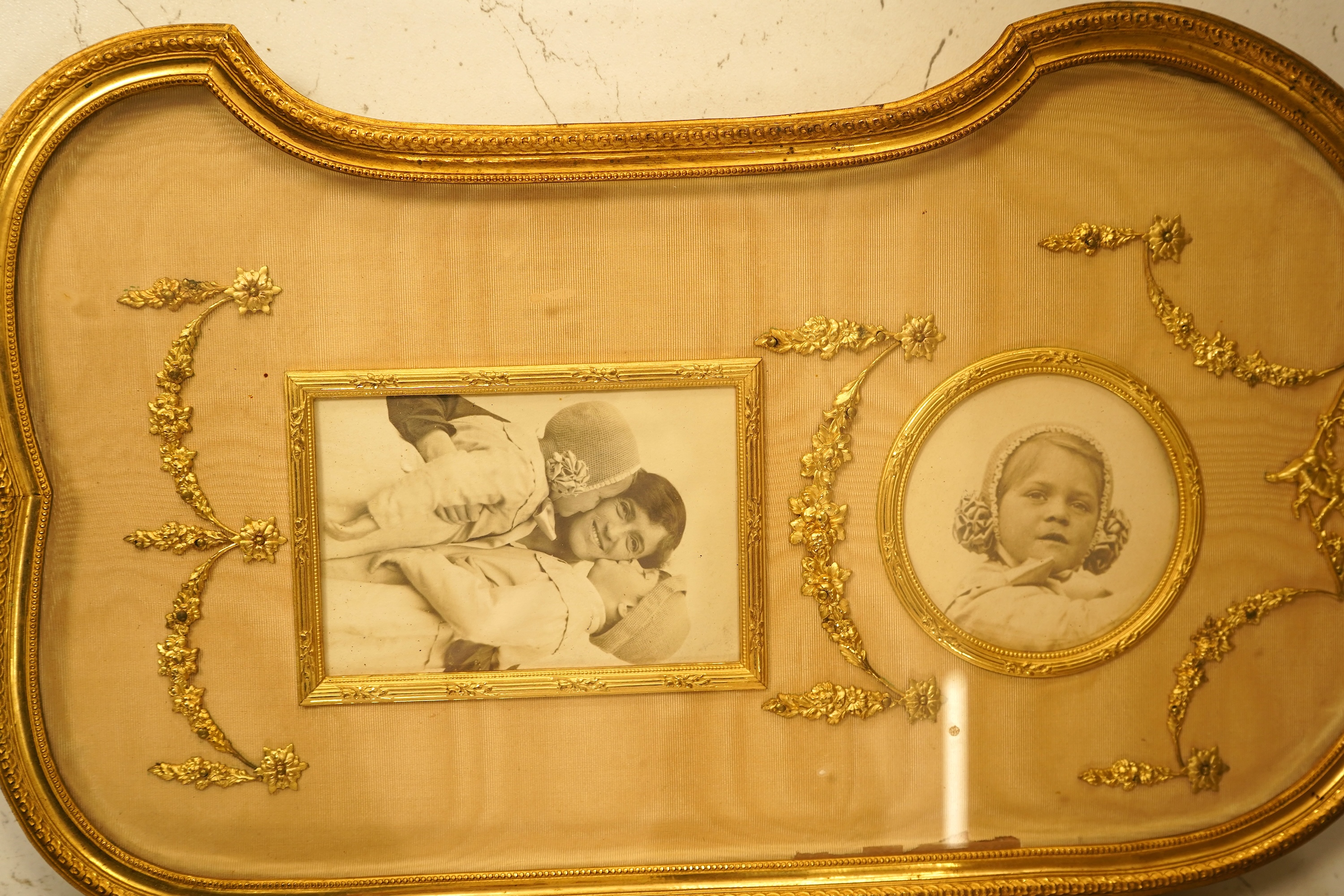 An Edwardian gilt framed triptych photo frame with watered silk backing, overall 72cm wide